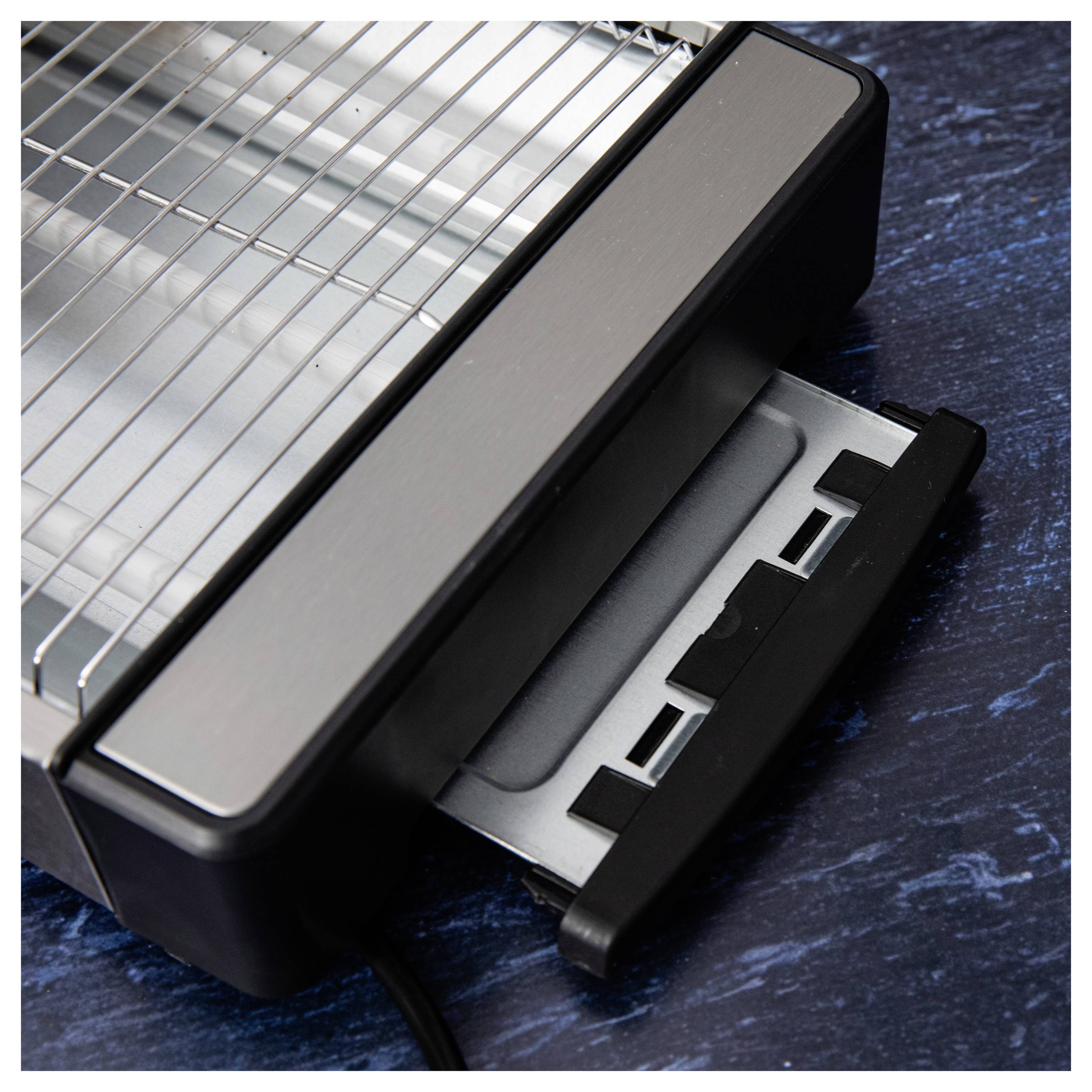 Une vue rapprochée d'un gril électrique sur une surface sombre, présentant un plateau de récupération des graisses amovible, améliorant ainsi la commodité et la facilité de nettoyage.