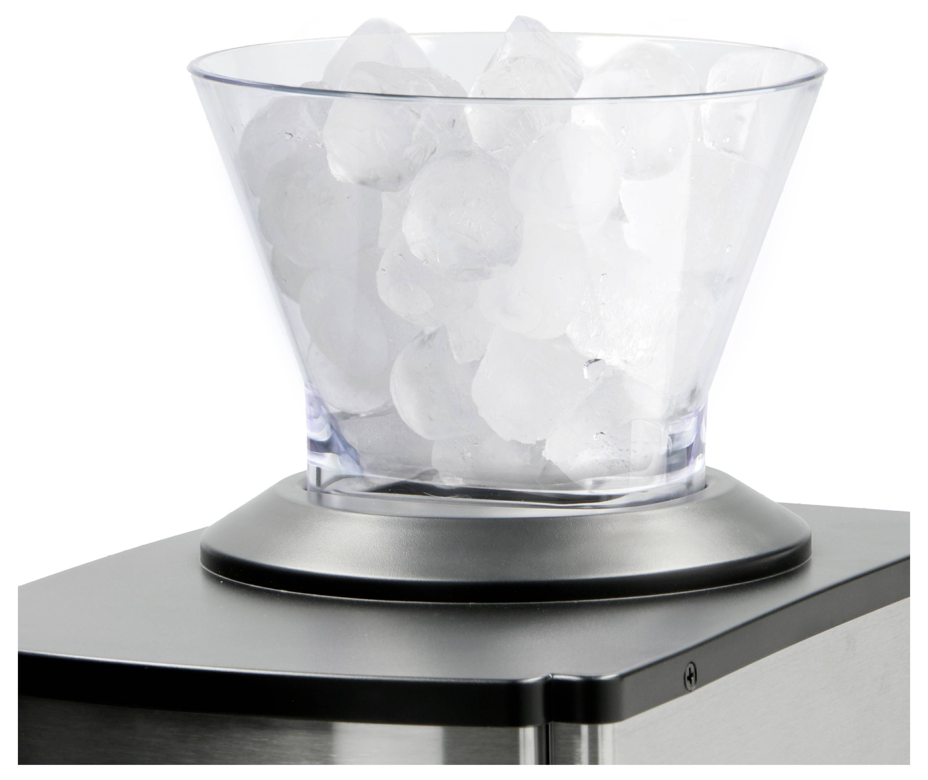 Un bol transparent rempli de glaçons repose sur un appareil métallique, probablement un fabricant ou un distributeur de glace, suggérant que l'appareil produit de la glace fraîche.