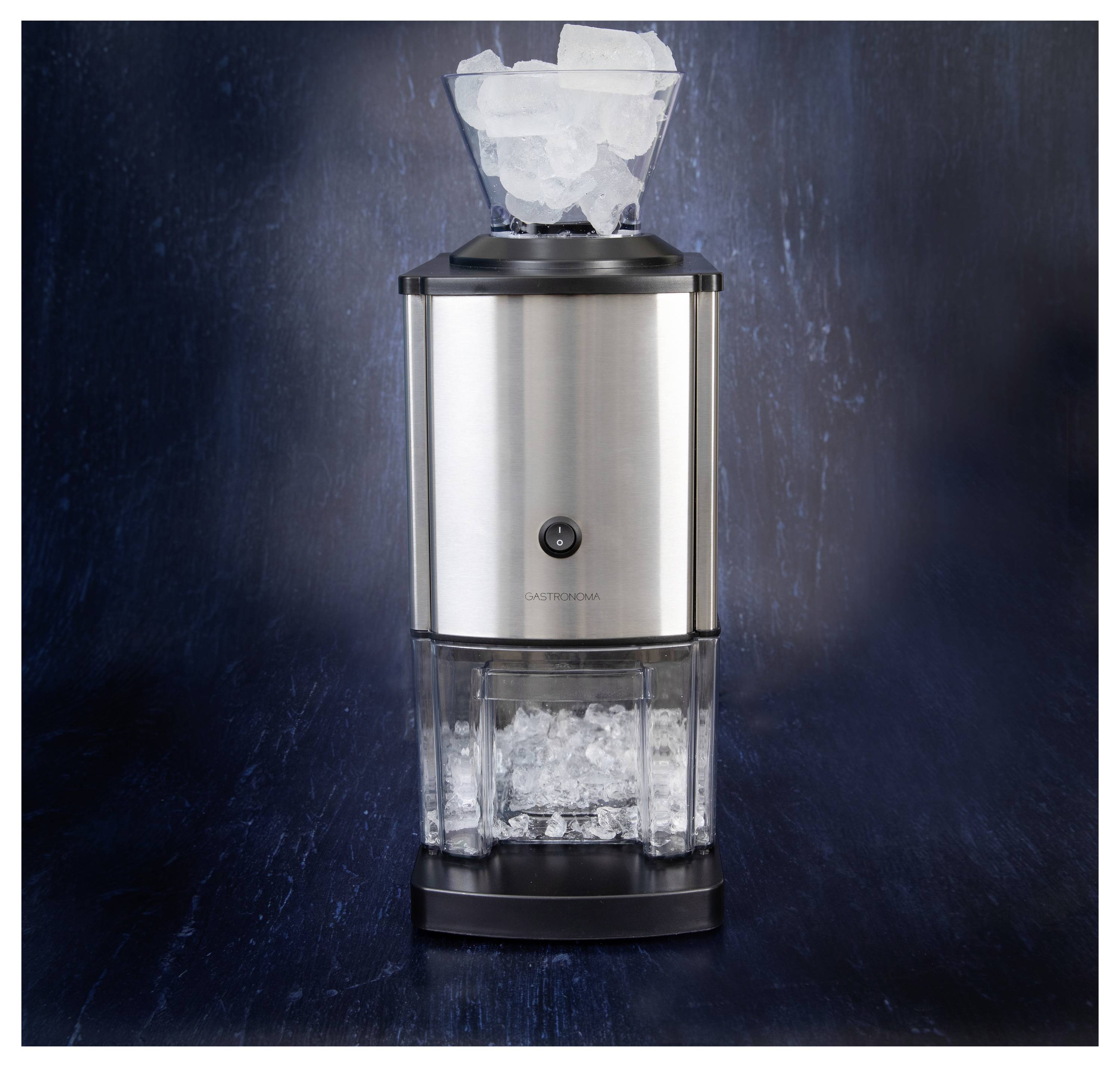 Une machine à écraser la glace en acier inoxydable avec des glaçons transparents empilés dans l'entonnoir supérieur et de la glace pilée collectée dans le conteneur inférieur.