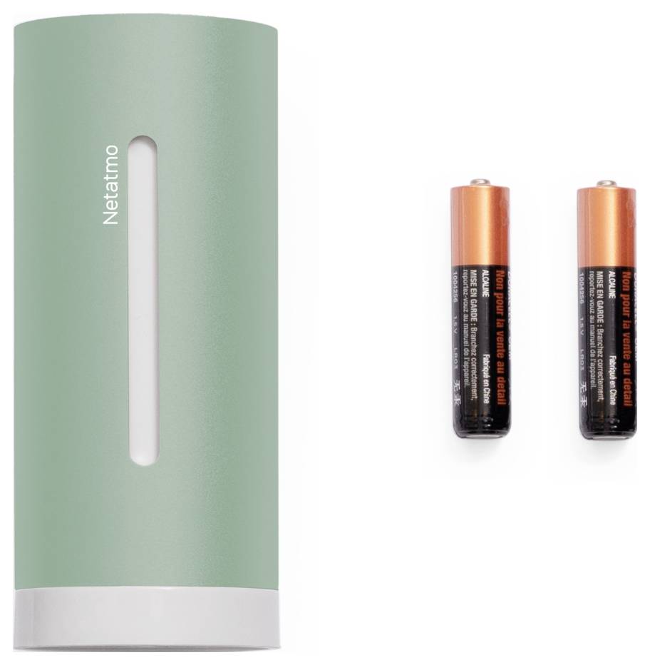Un capteur cylindrique vert étiqueté « Netatmo » à côté de deux piles AA.