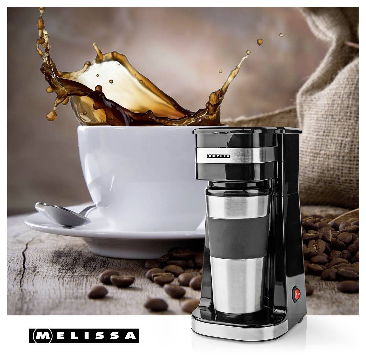 Un cafetière moderne au premier plan avec une tasse blanche de café éclaboussant sur une surface en bois, entourée de grains de café.