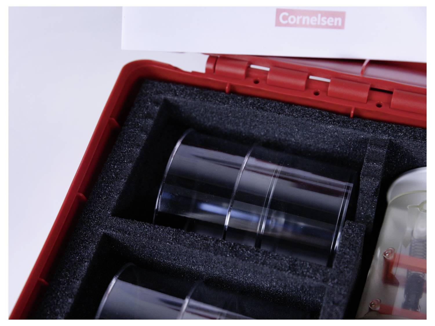 Close-up of a Cornelsen science kit with transparent containers neatly arranged in a red case.