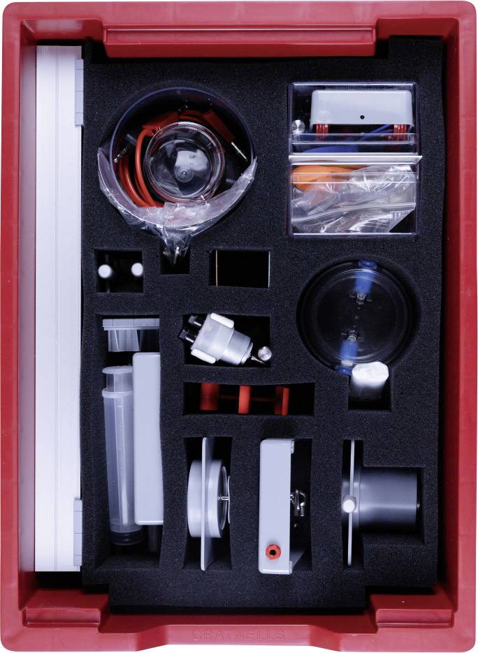 Un plateau rouge rempli de divers outils et équipements d'expériences scientifiques, organisés dans des compartiments en mousse, vue de dessus.