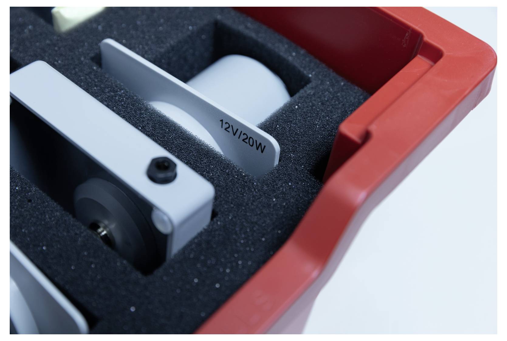 '12V/20W' text is visible on a component in a protective foam casing with gray and red colors. The component is part of an electrical device.
