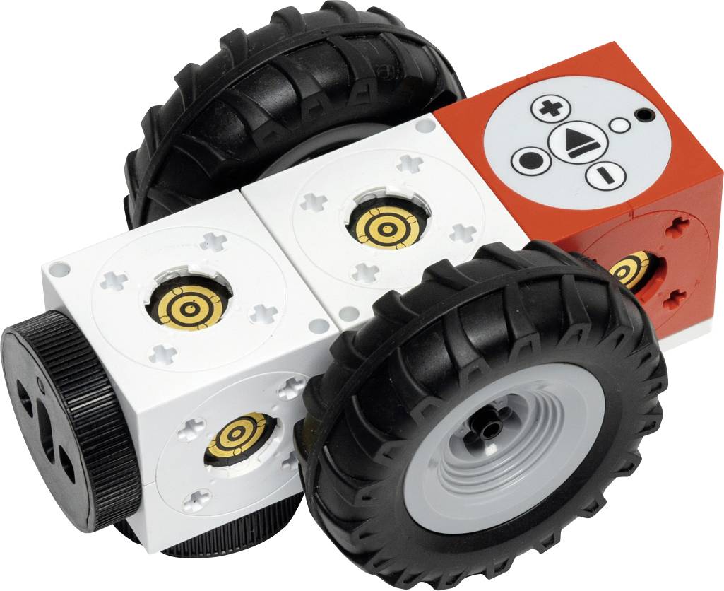 Un petit jouet robot avec deux grandes roues noires. Il a un corps blanc et rouge avec des connecteurs sur le dessus, ressemblant à un bloc de jouet de construction.