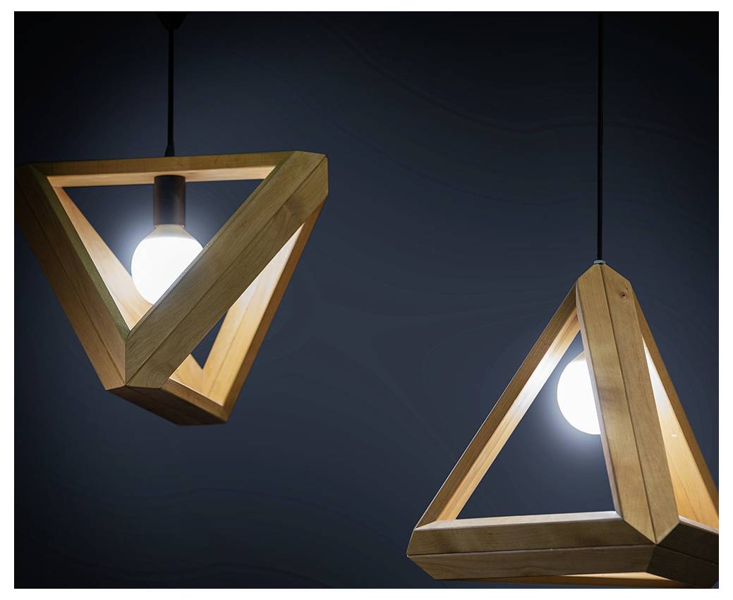 Deux luminaires suspendus triangulaires en bois avec des ampoules apparentes sur un fond sombre.