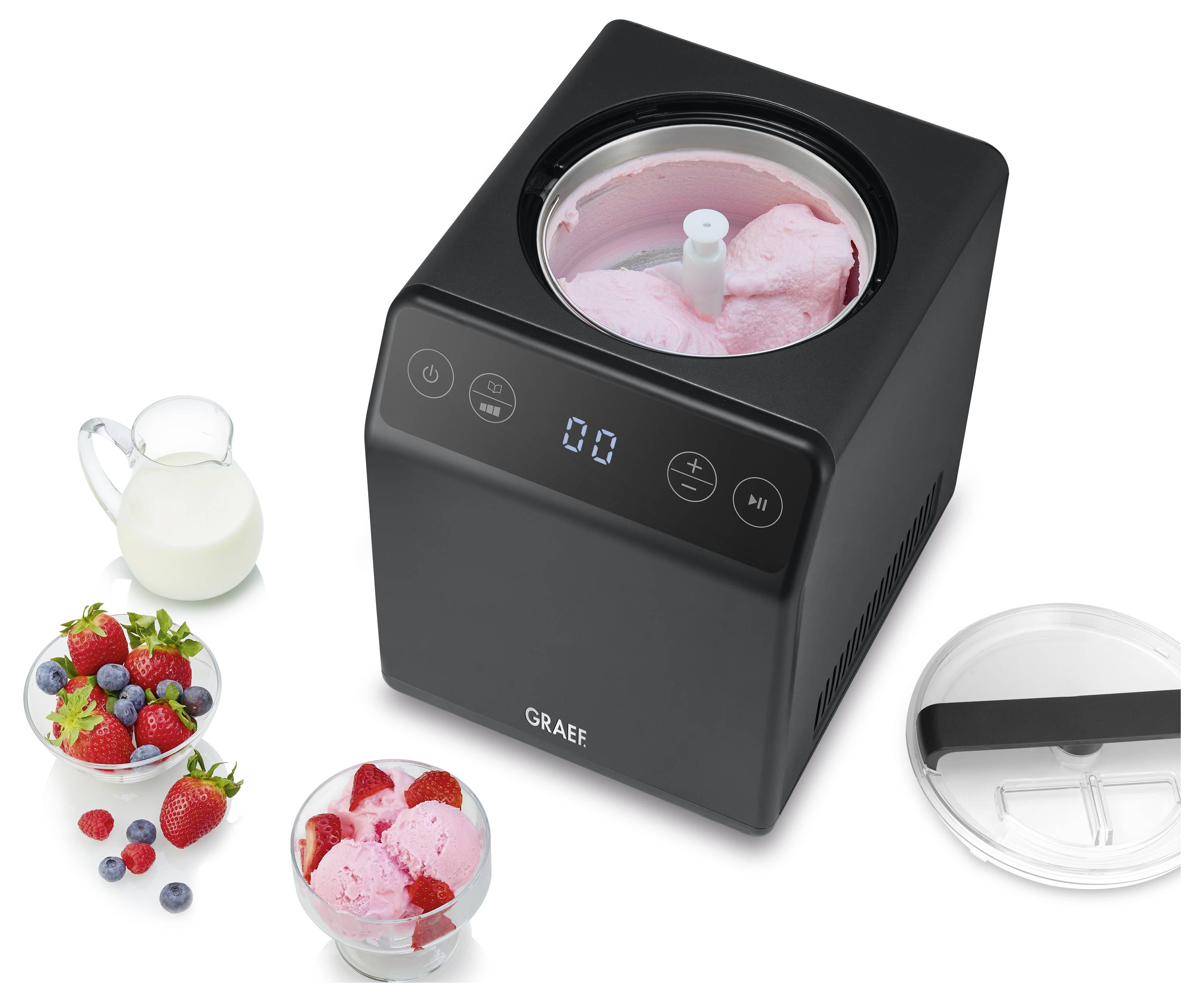 Un sorbetier noir contenant de la glace à la vanille, entouré de bols de fraises et d'une cruche de lait, illustrant la préparation d'un dessert.