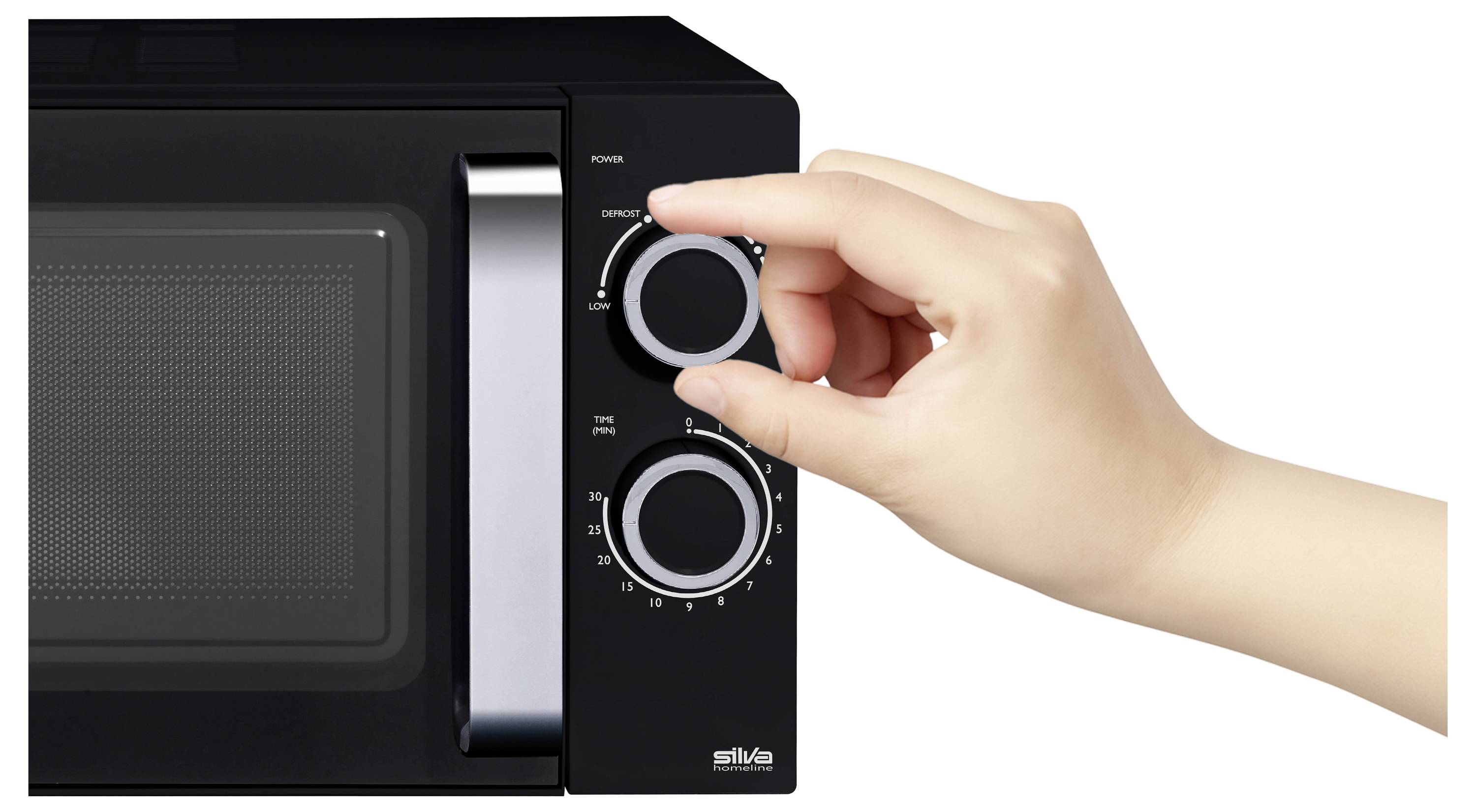 Une main ajuste le cadran du minuteur d'un four à micro-ondes noir. L'appareil dispose d'un bouton de réglage de la puissance et d'un grillage visible sur la porte.