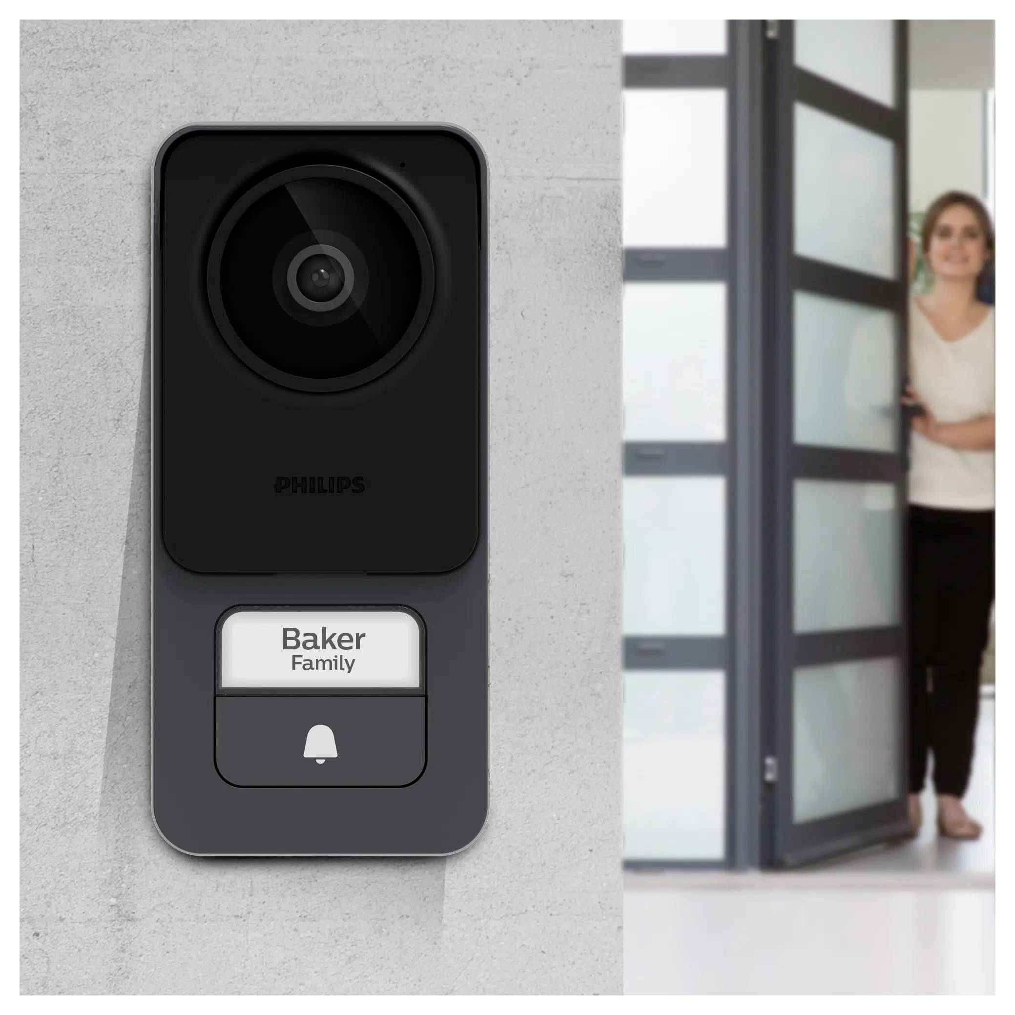 Une femme ouvre une porte en arrière-plan. Au premier plan, se trouve une sonnette intelligente étiquetée « Famille Baker » avec une caméra.