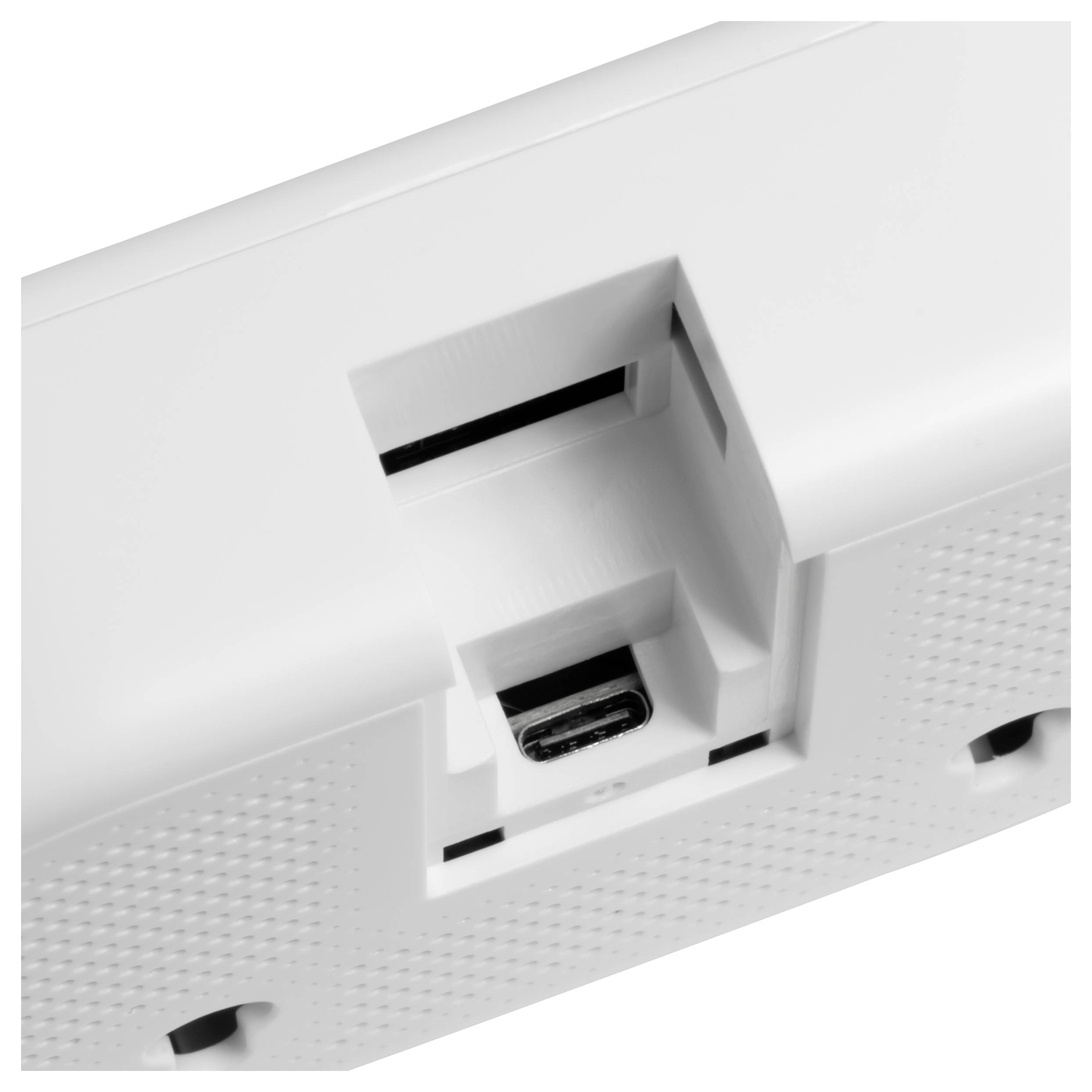 Gros plan d'un projecteur blanc monté au plafond montrant l'objectif, les fentes de ventilation et le boîtier de montage.