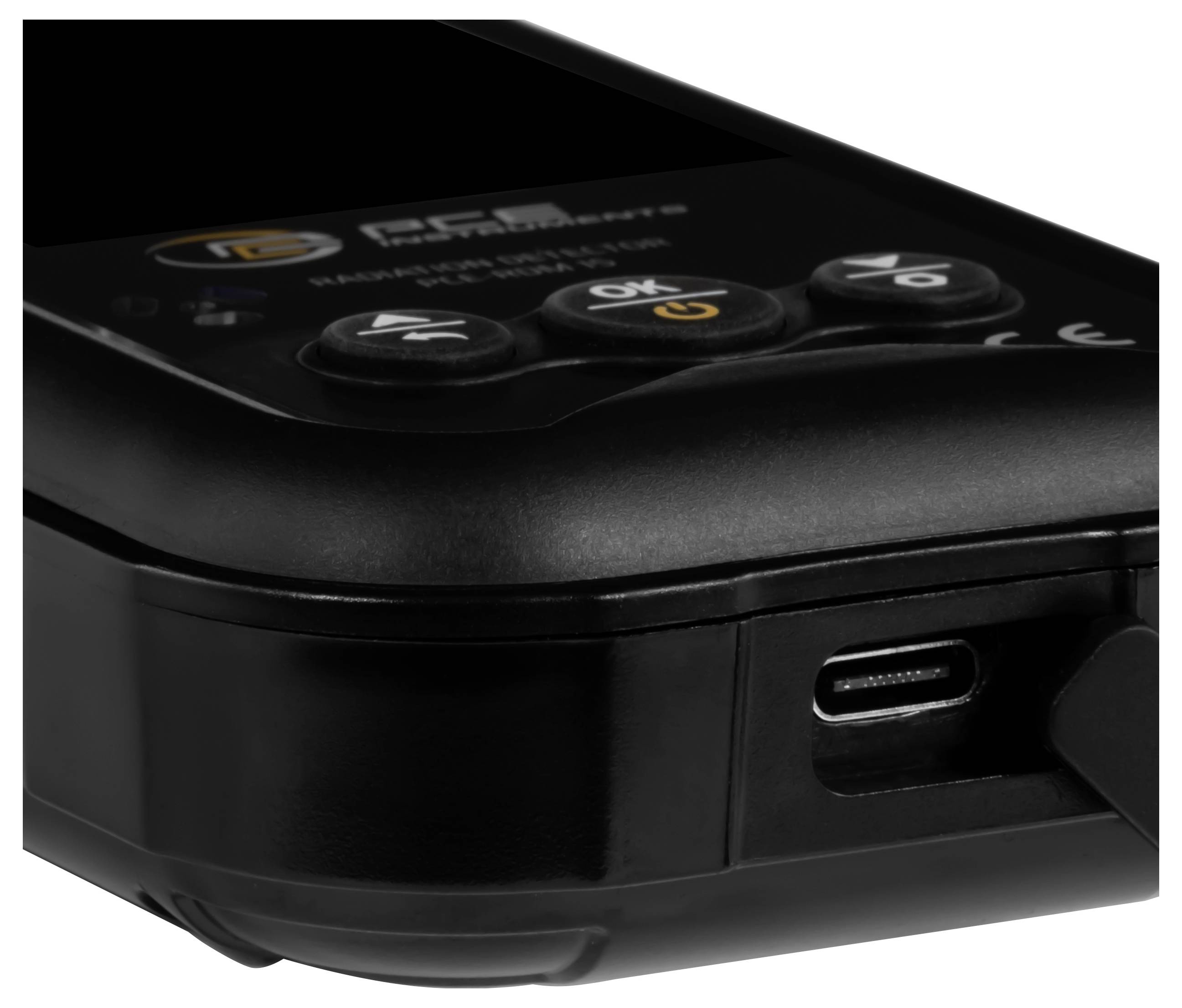 Gros plan d'un appareil électronique noir avec des boutons de commande surélevés et un port de charge USB-C sur la face avant.