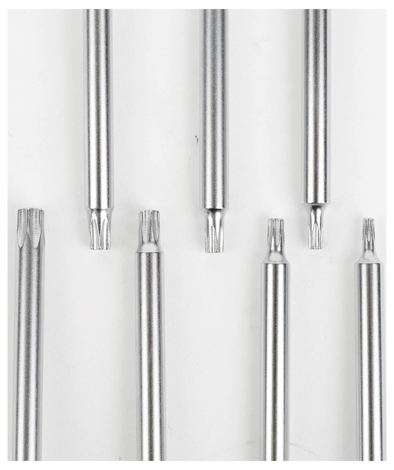 Outils métalliques avec diverses pointes entaillées, arrangés verticalement, mettant en évidence différents motifs.