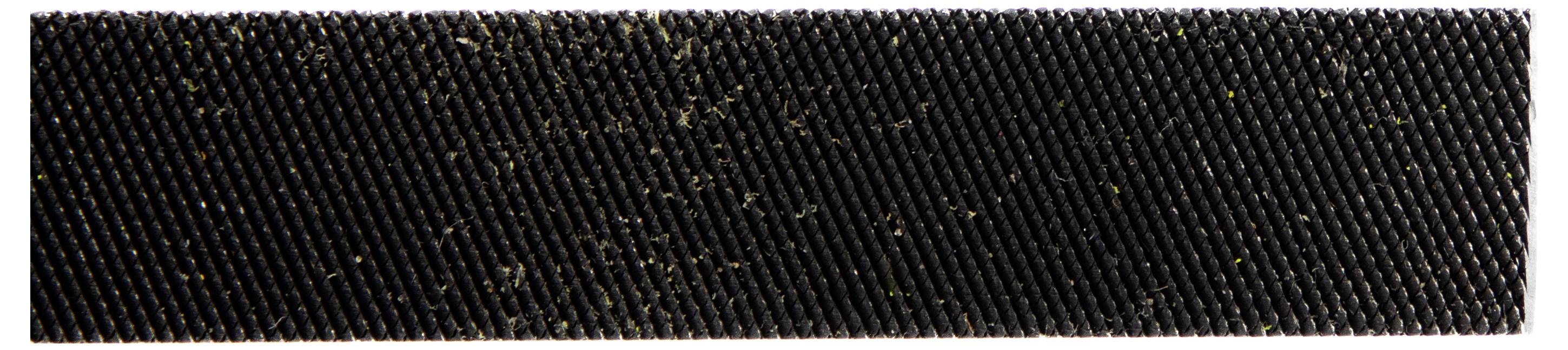 Une vue rapprochée d'une surface noire texturée avec des débris fibreux éparpillés dessus.