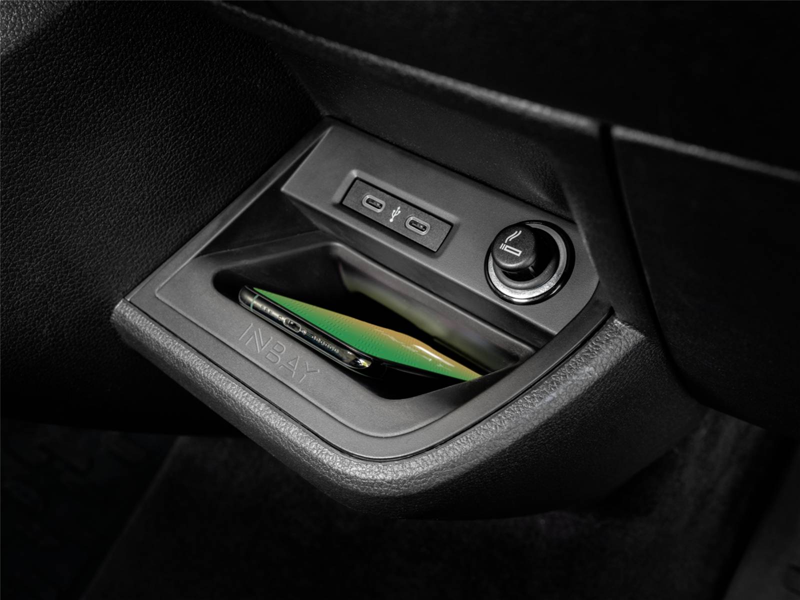 Plateau de rangement central de voiture avec deux ports USB et une prise d'alimentation 12V, contenant un téléphone intelligent et des cartes.