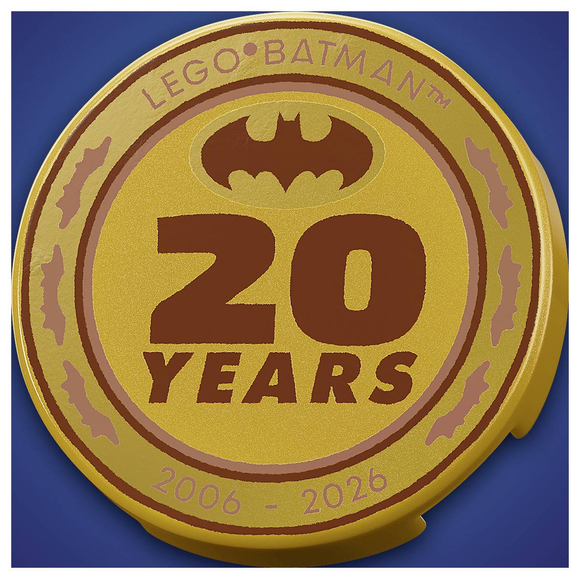 A gold coin with 'LEGO Batman' at the top, a bat symbol, and '20 Years 2006-2026' in large text, celebrating an anniversary.