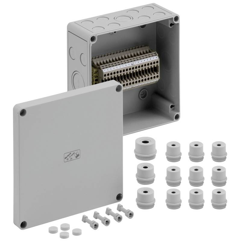 Boîte de jonction électrique grise avec couvercle à charnière, blocs de bornes à l'intérieur, et assortiment de presse-étoupe et de fiches disposés à côté.