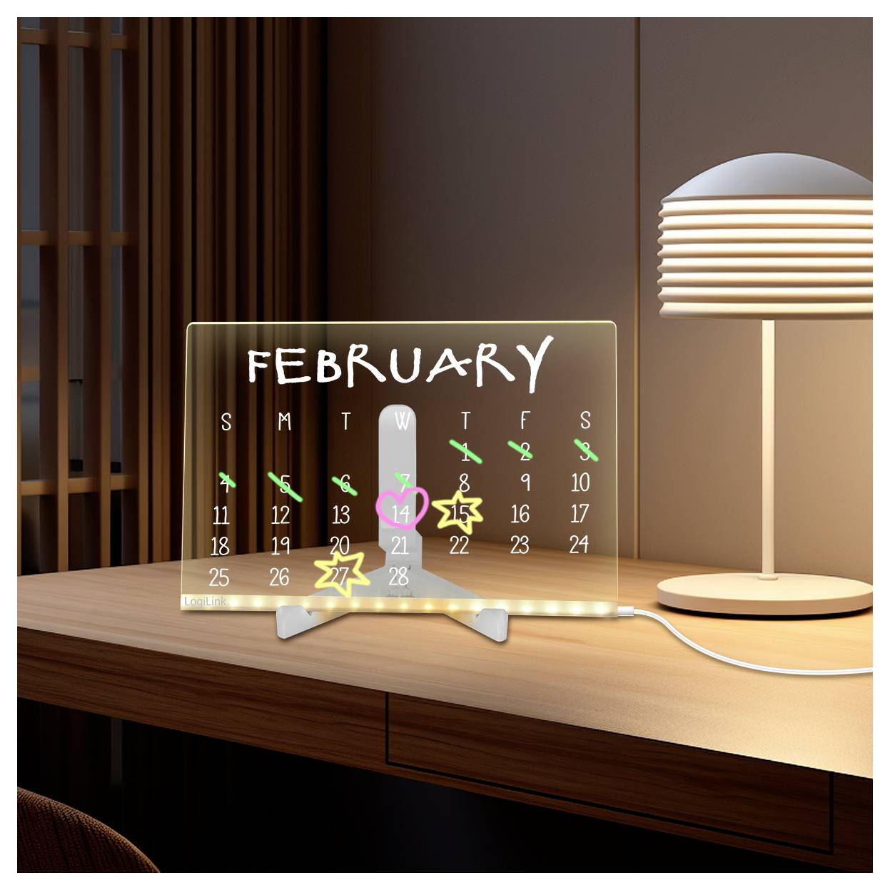 A digital calendar on a wooden desk displays February 2023. February 14 is marked with a heart, indicating Valentine's Day. A lamp is lit beside it.