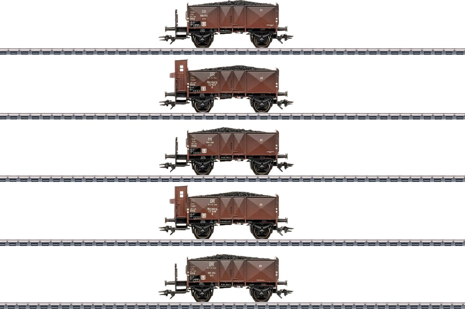 Quatre wagons de fret bruns chargés de charbon, alignés verticalement sur des voies parallèles, illustrant la structure d'un train ou l'arrangement de la cargaison.
