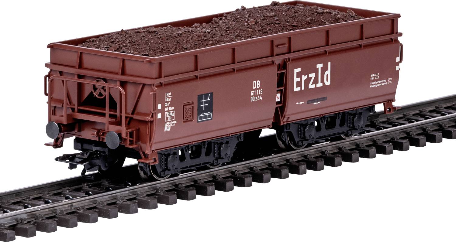Un wagon de fret de train miniature rempli de minerai brun-rougeâtre étiqueté « Erz Id » sur une voie, présentant un véhicule de transport miniature réaliste.