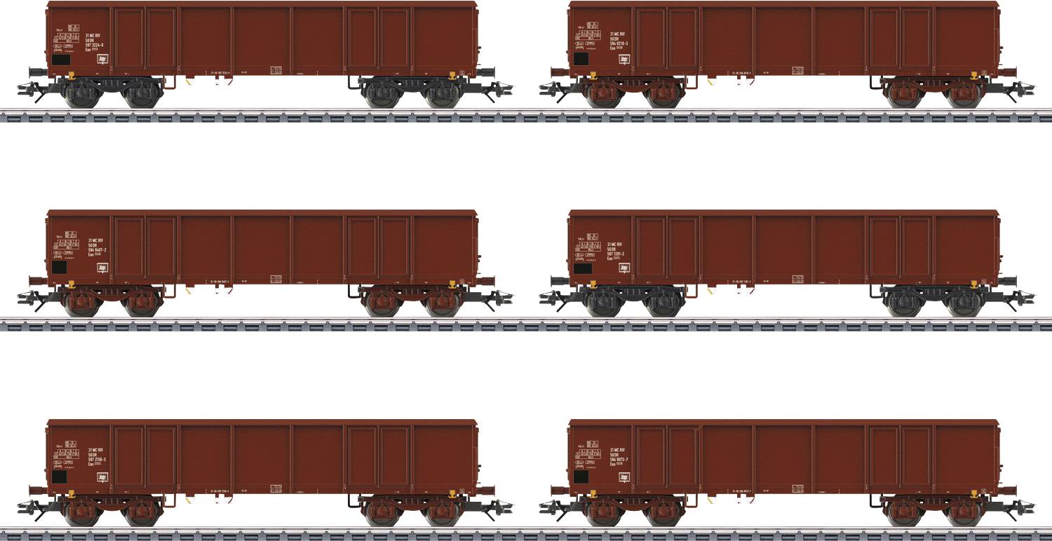 Six wagons de marchandises rouges identiques sont alignés en deux rangées de trois, reposant sur des voies parallèles sur un fond blanc uni.