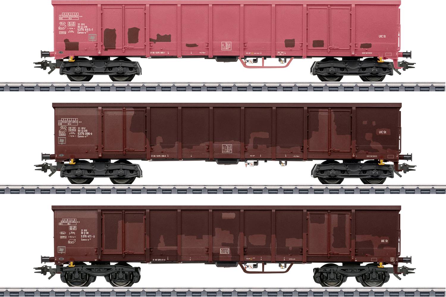 Trois vues latérales de wagons de train de marchandises sur les rails ; le wagon supérieur est rouge, les wagons du milieu et du bas sont brun foncé, tous avec du texte blanc.