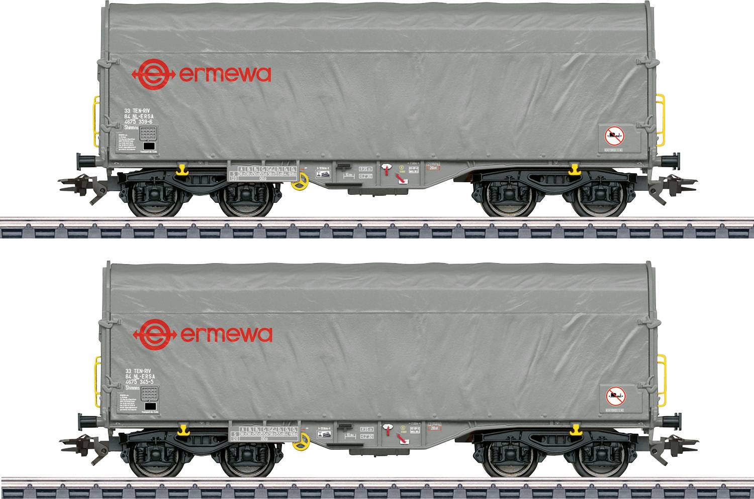 Un wagon de fret gris avec le logo « ermewa » en rouge sur le côté, stationné sur une voie ferrée. Le wagon porte des étiquettes d'avertissement et de sécurité.