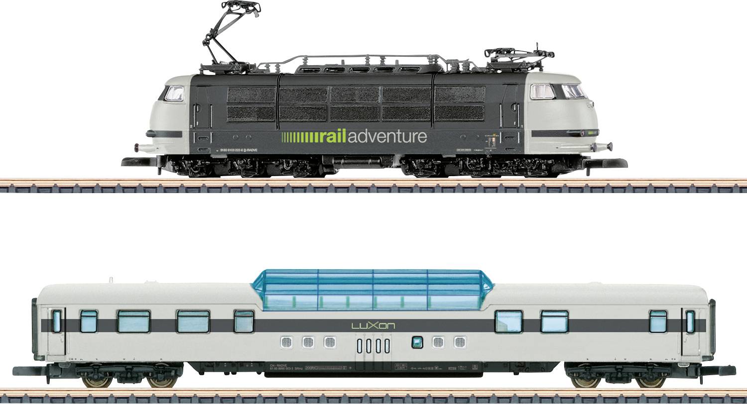 Les trains modèles circulent sur des voies parallèles ; en haut se trouve une locomotive noire portant l'étiquette « railadventure », en bas se trouve un wagon de passagers blanc portant l'étiquette « LUXON ».