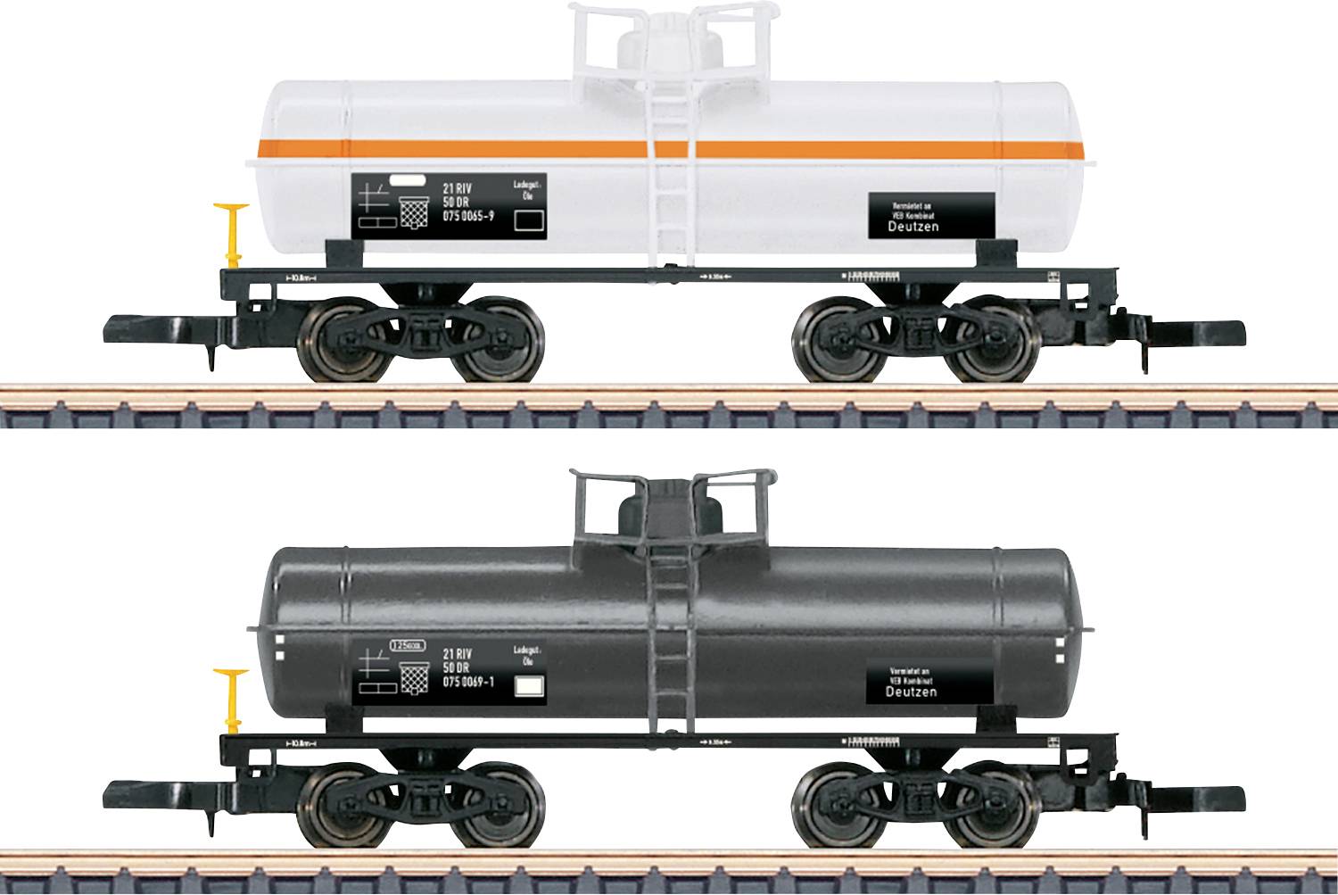 Deux wagons-citernes de trains miniatures sur une voie : l'un blanc avec une bande orange, l'autre noir. Les deux ont des textes détaillés et des marquages sur les côtés.