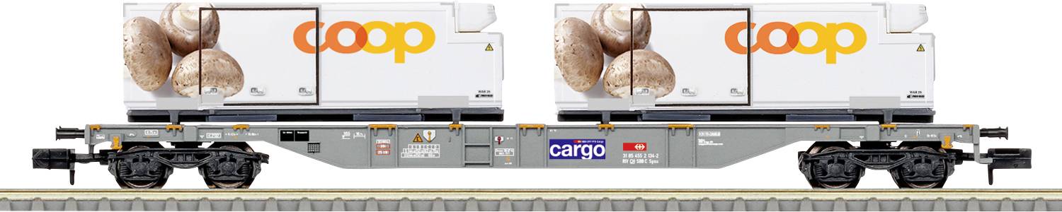 Un wagon de train de marchandises étiqueté « coop », chargé de conteneurs contenant des petits pains, est situé sur une voie ferrée.