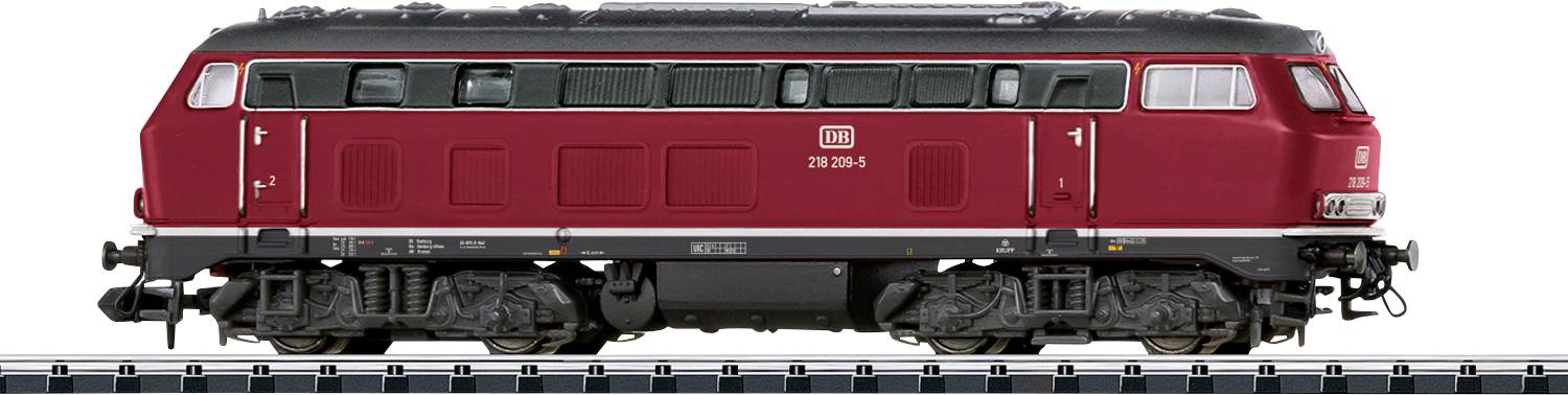 Une locomotive diesel rouge avec un corps profilé et plusieurs fenêtres est exposée sur une voie, mettant en évidence les roues et les mécanismes détaillés.