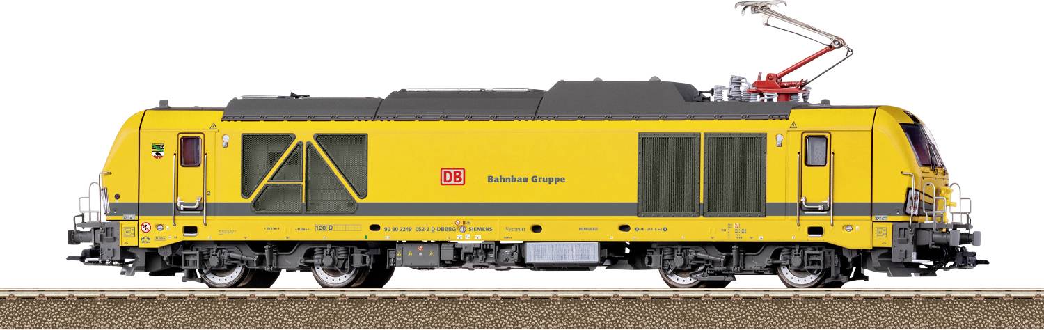 Une locomotive jaune d'entretien ferroviaire sur des rails, étiquetée « DB Bahnbau Gruppe », avec des connexions électriques aériennes, vue de côté.