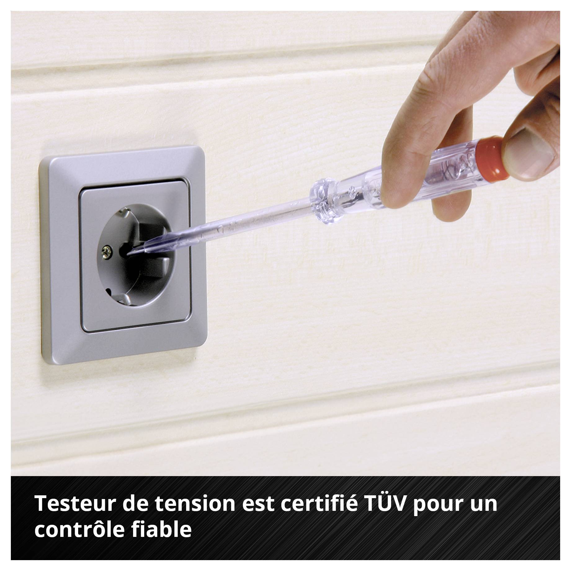 Eine Hand hält einen Schraubenzieher-Phasenprüfer in eine Wandsteckdose. Text unten: 'Phasenprüfer ist TÜV-geprüft für zuverlässige Spannungsprüfung'.