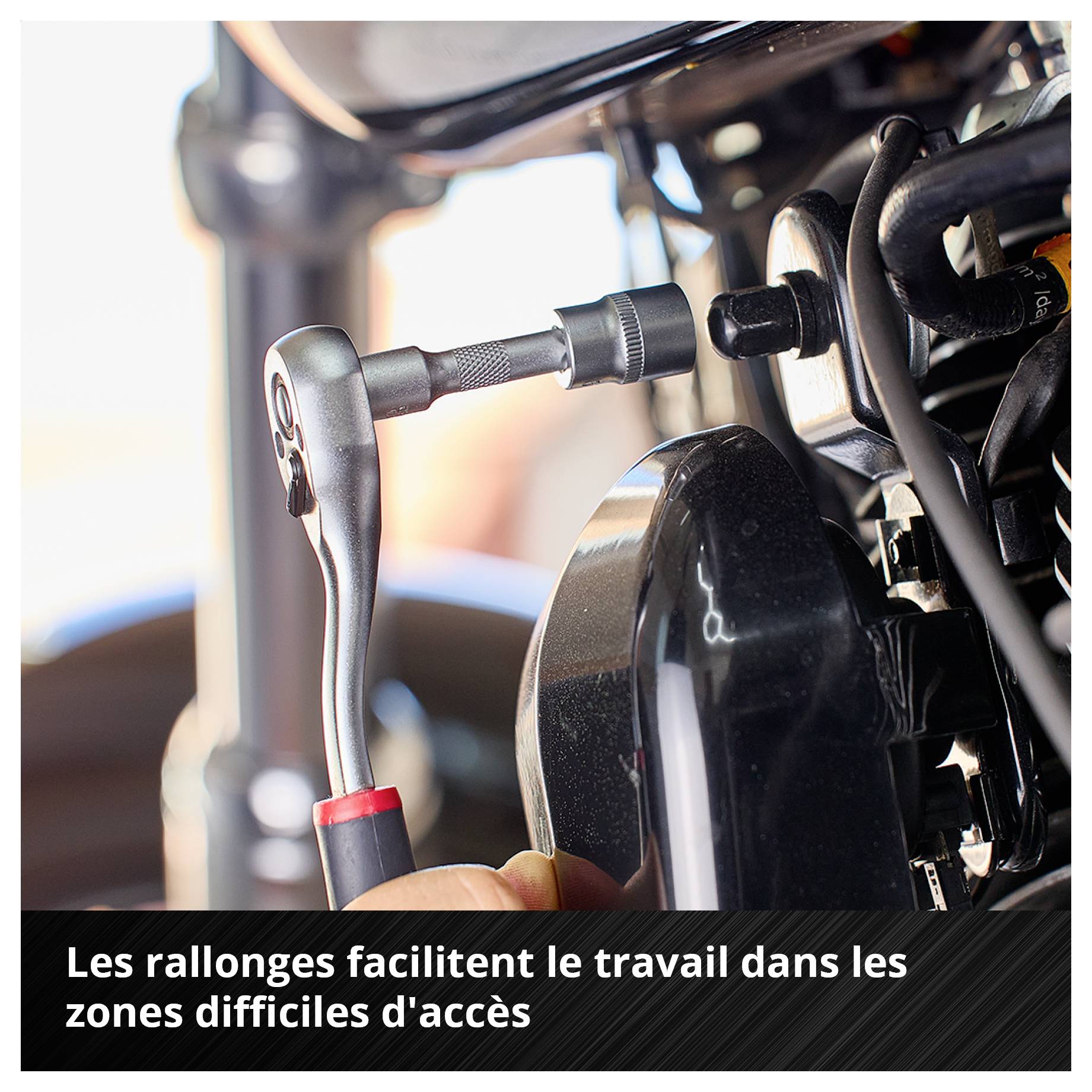 Eine Ratsche mit Verlängerung wird an einem schwer erreichbaren Teil eines Motors verwendet. Text: 'Verlängerungen erleichtern das Arbeiten an schwer erreichbaren Stellen'.