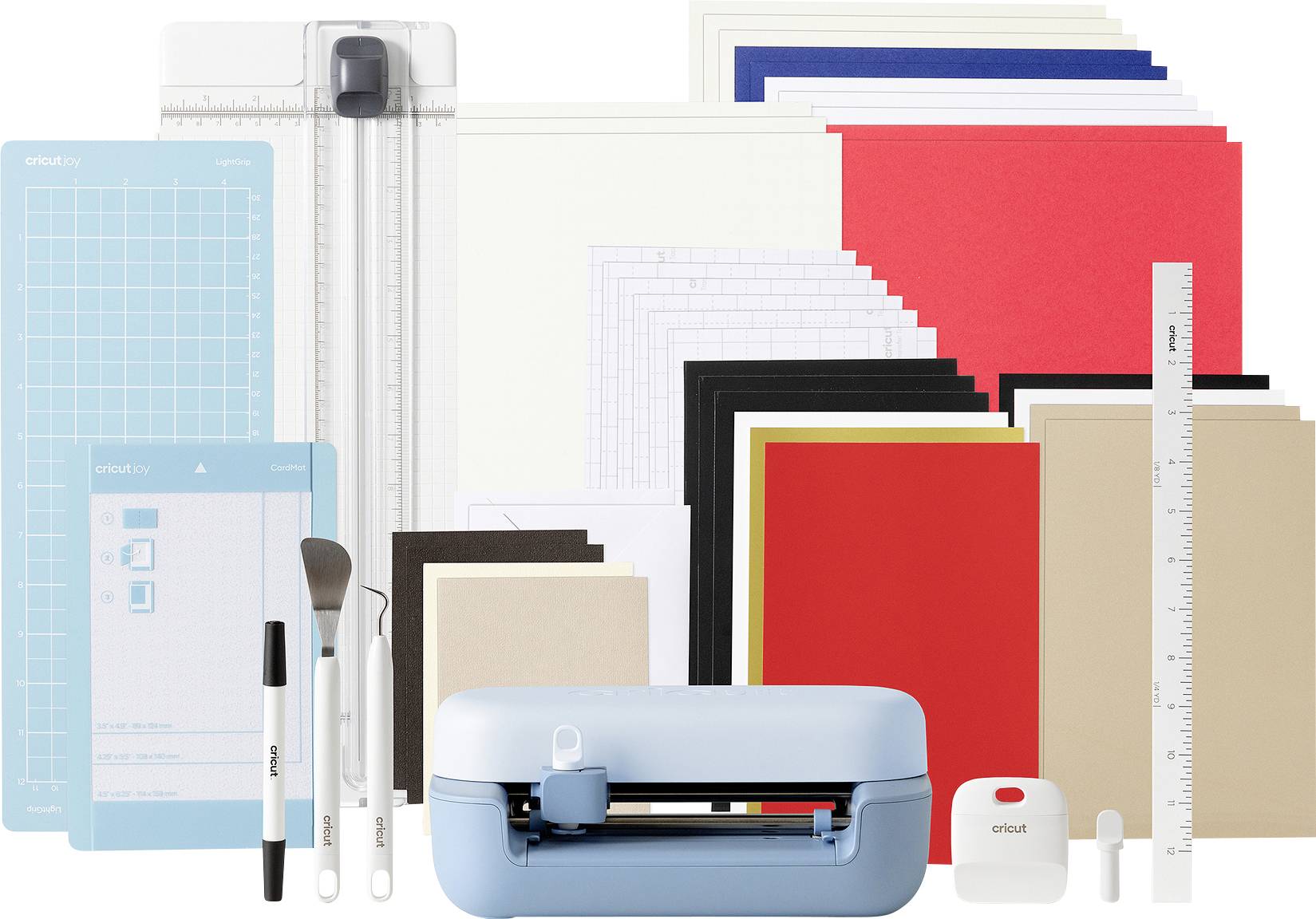 Un ensemble de machine de découpe Cricut avec diverses accessoires et matériaux colorés, comprenant des règles, des stylos et des tapis de découpe, pour des projets de loisirs créatifs.