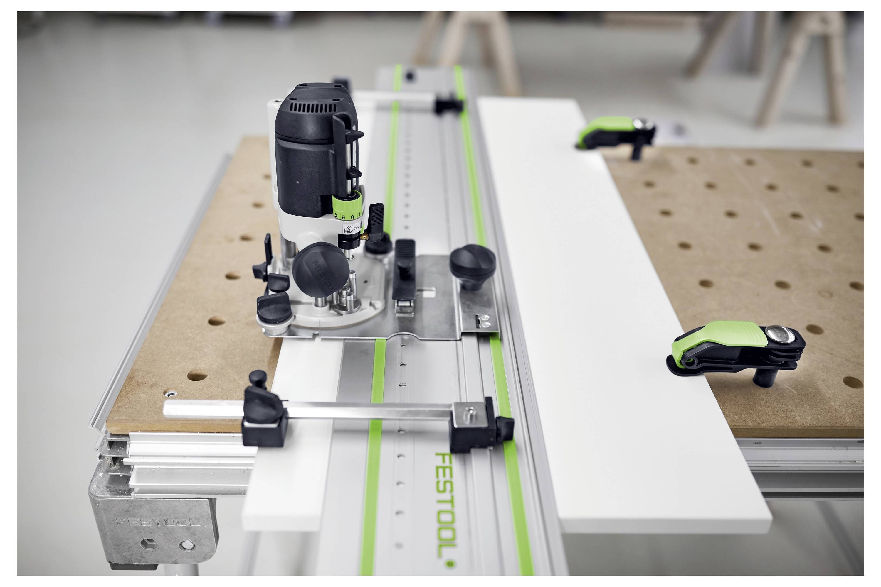 Un routeur de table avec un rail de guidage sur un établi, utilisé pour les tâches de découpe et de façonnage précis du bois.