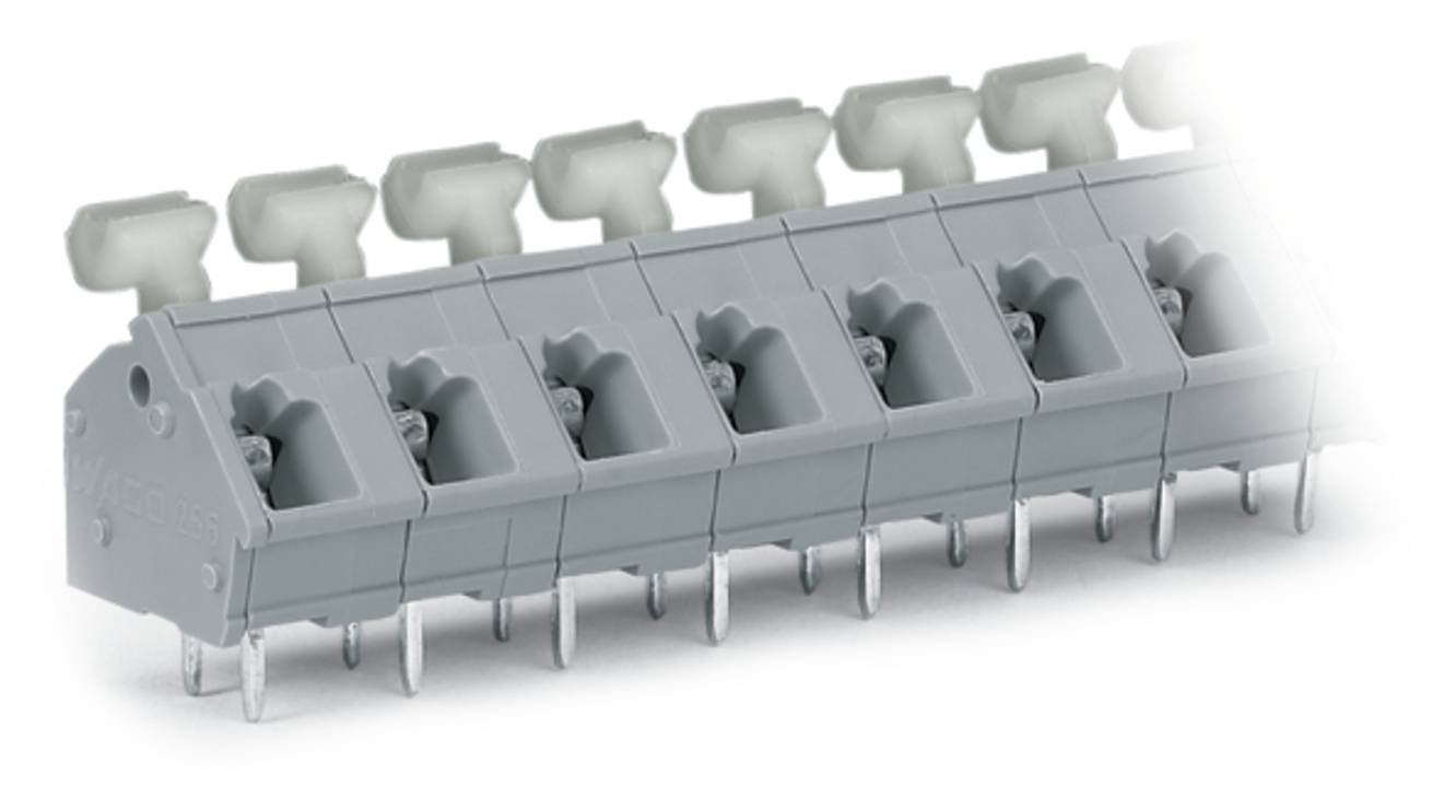 Ein grauer Terminalblock mit sechs Anschlüssen und metallischen Steckern an der Unterseite, der für elektrische Verbindungen in verschiedenen Geräten verwendet wird.
