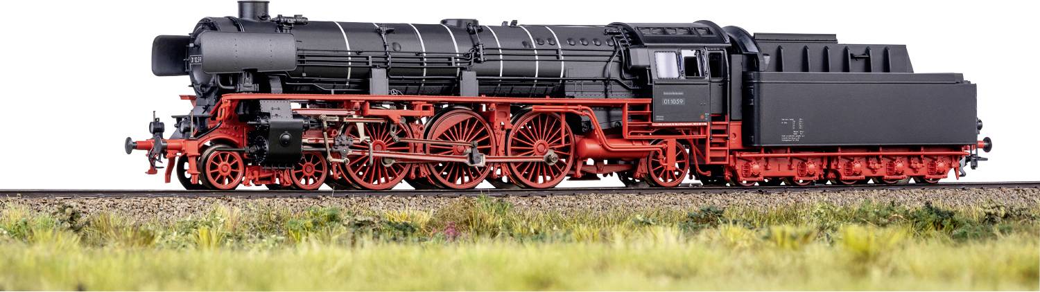 Un train miniature détaillé avec une locomotive noire et rouge sur une voie ferrée entourée d'herbe, mettant en avant les roues complexes et les pièces mécaniques.