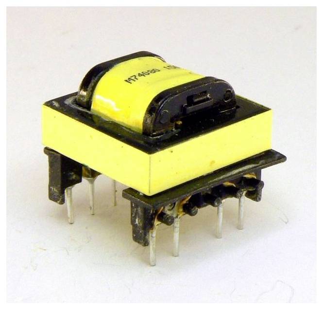 A small yellow electronic transformer with six metallic pins, used in power supplies for voltage conversion.