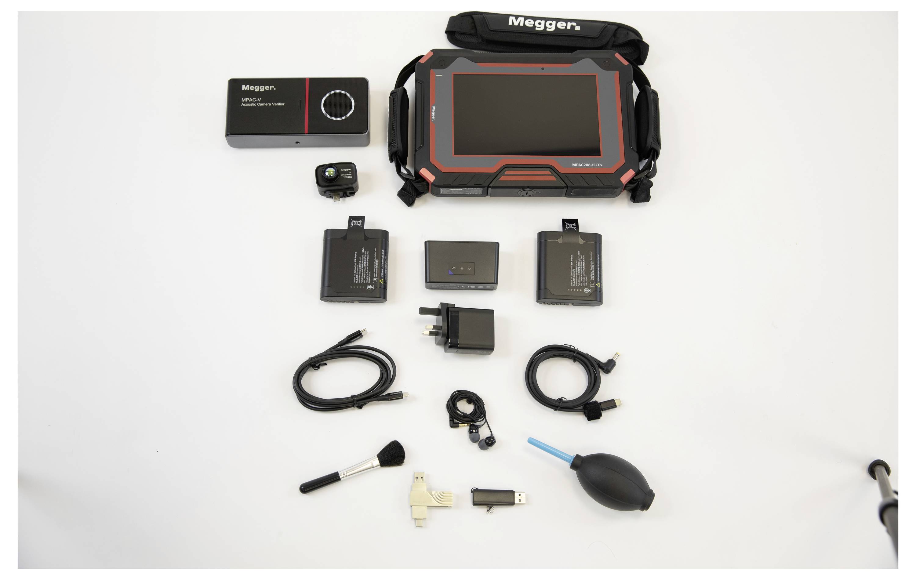 'Ensemble d'équipements électroniques comprenant un grand appareil Megger, de petits gadgets, des câbles, un appareil photo, une clé USB, des outils de nettoyage et des piles.'