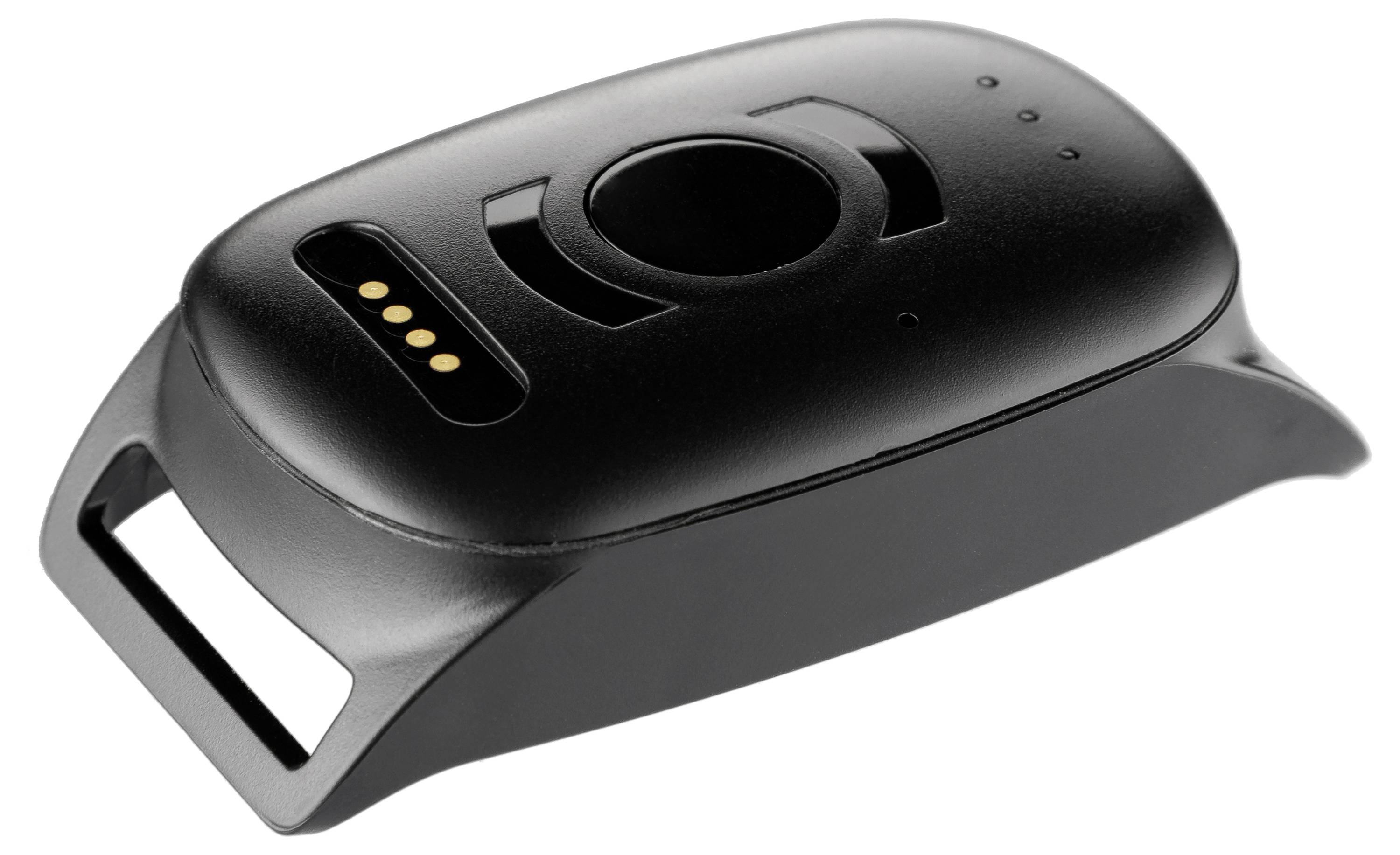 Un appareil électronique noir avec un port de charge et un bouton sur le dessus, reposant sur une surface blanche.