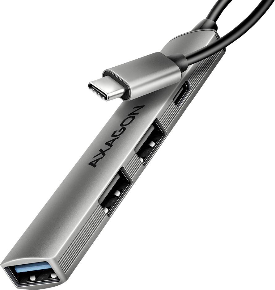 Un concentrateur USB-C métallique avec plusieurs ports USB, portant l'étiquette « AYAGON », permet la connectivité des appareils et le transfert de données.
