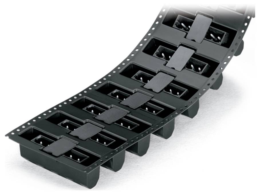 Une bobine de petits composants électroniques noirs sur un ruban, utilisée pour l'assemblage automatisé dans la fabrication électronique.