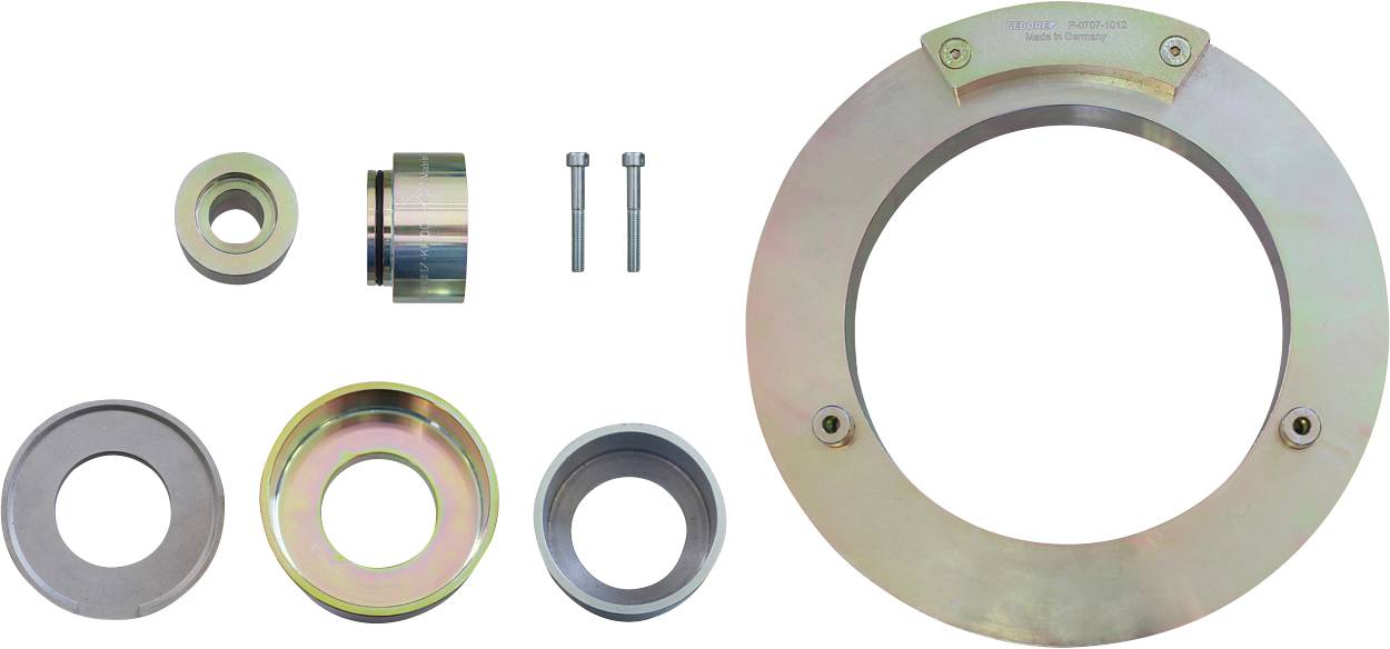 Un ensemble d'outils automobiles métalliques comprenant une grande plaque circulaire, des anneaux plus petits et deux boulons, utilisés à des fins de réparation automobile.