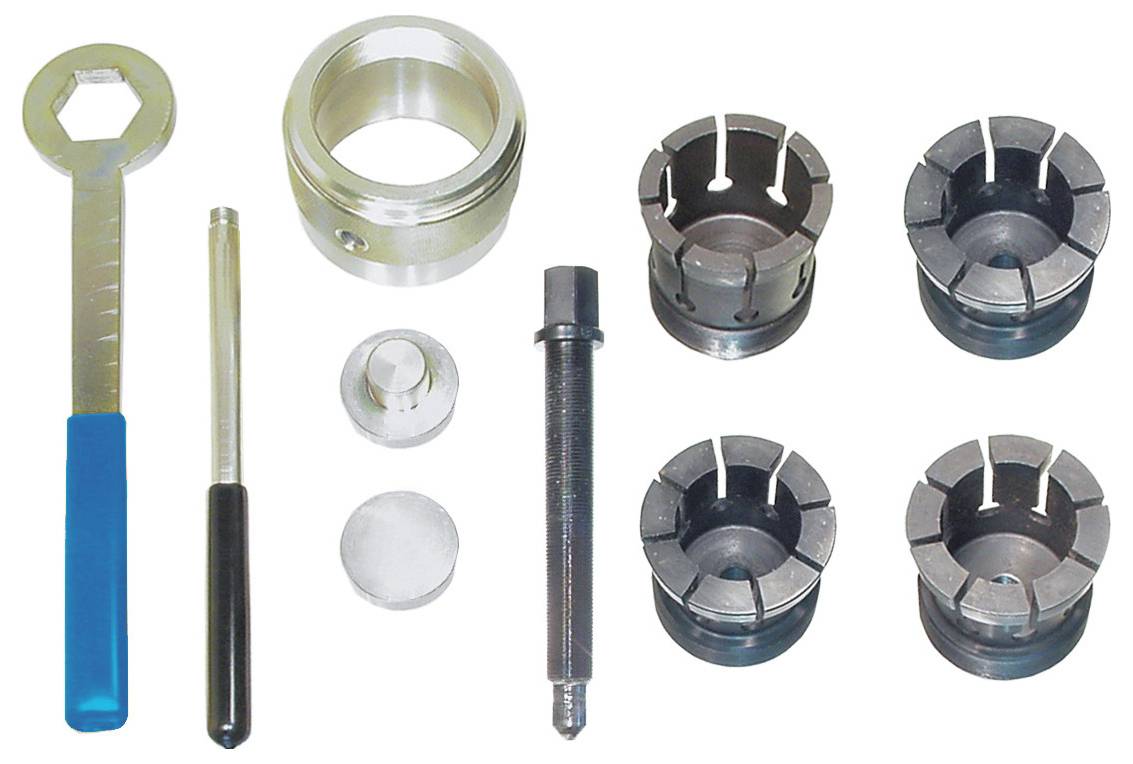 A set of metal tool components arranged in rows, including a wrench, collets, and various cylindrical and cylindrical items for assembly or repair.