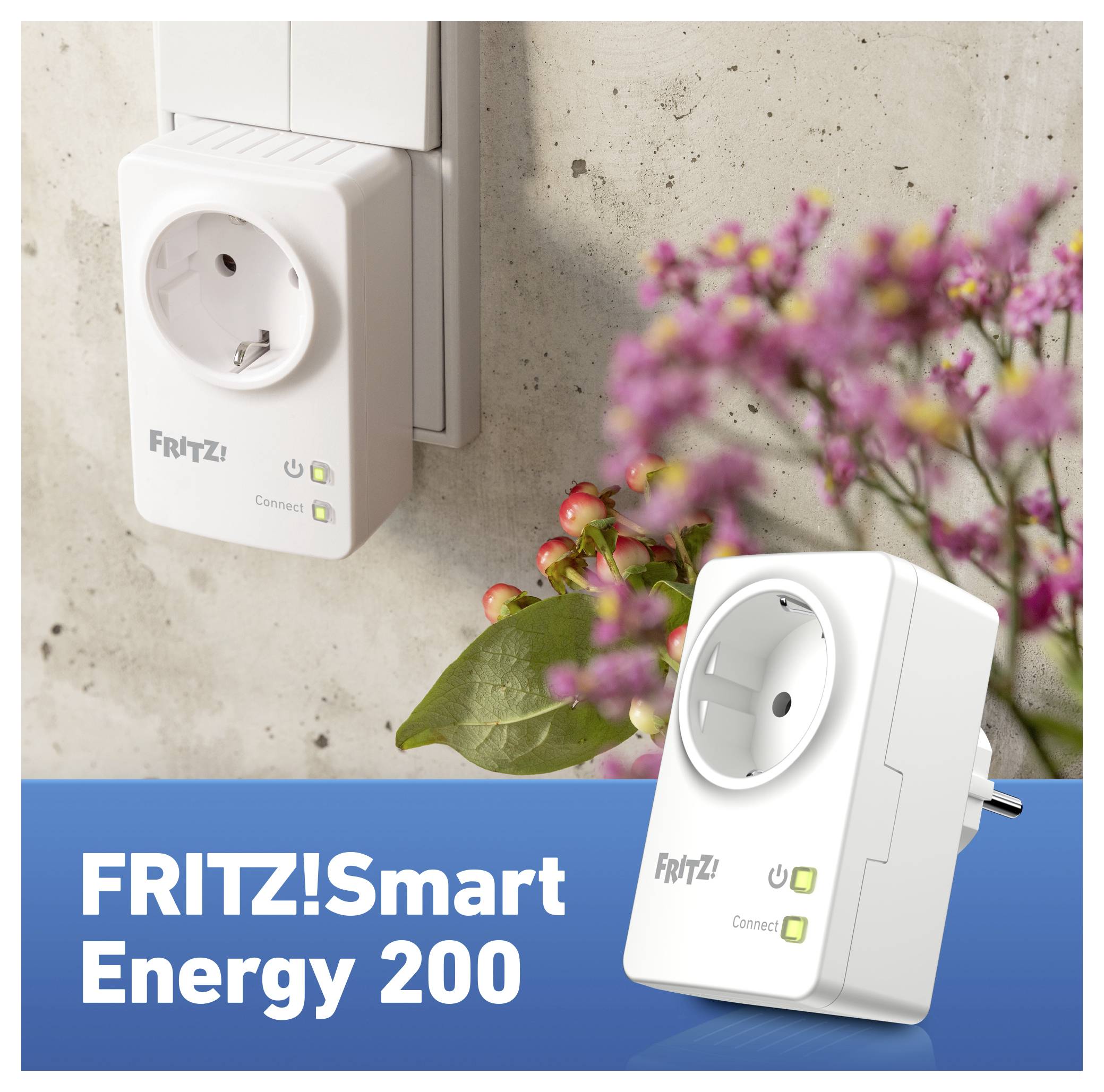 'FRITZ!Smart Energy 200' plug in wall socket with green indicator lights on, surrounded by blurred flowers, indicating power and connectivity features.