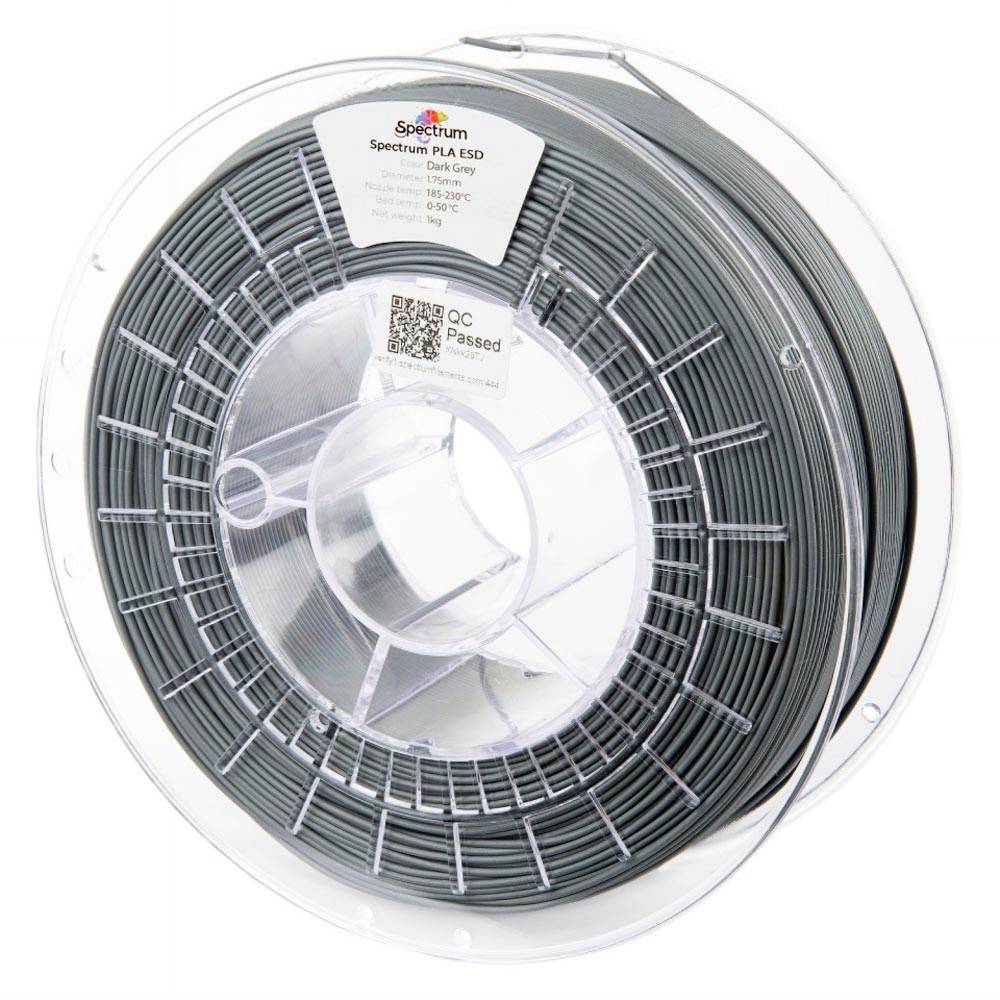 Bobine de filament pour imprimante 3D gris foncé sur une bobine en plastique transparent, étiquetée Spectrum PLA ESD et QC Passed.