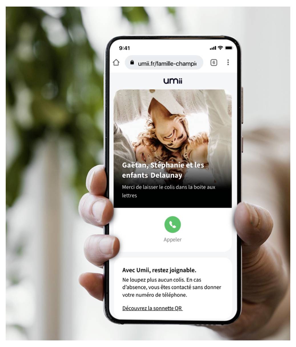 Un smartphone affiche une page web avec « umii » en haut. En dessous, une photo de famille est étiquetée « Gaëtan, Stephanie et les enfants Delaunay. »