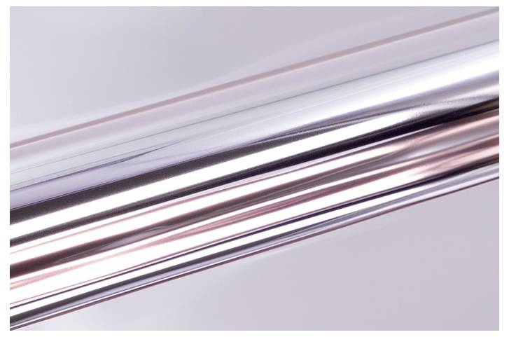 Une tige métallique brillante avec une surface réfléchissante, positionnée en diagonale sur un fond pâle, mettant en évidence sa texture lisse et polie.