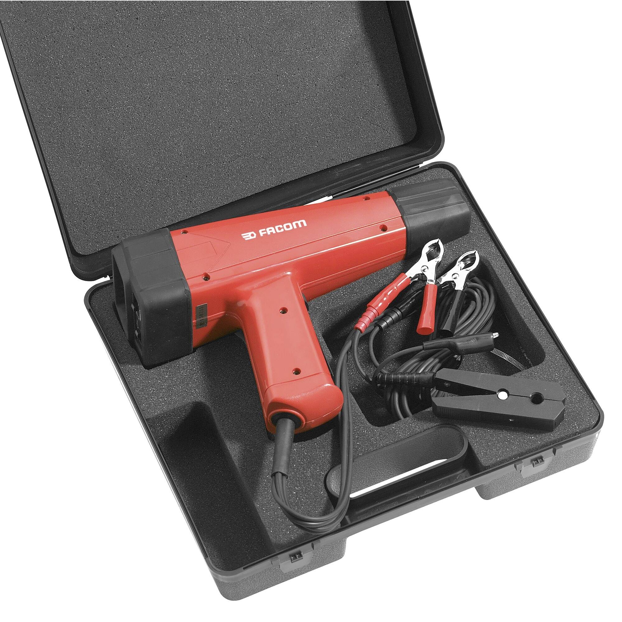 Un pistolet de synchronisation rouge avec des câbles, placé dans une mallette de transport noire, utilisé pour régler l'allumage moteur dans les véhicules.