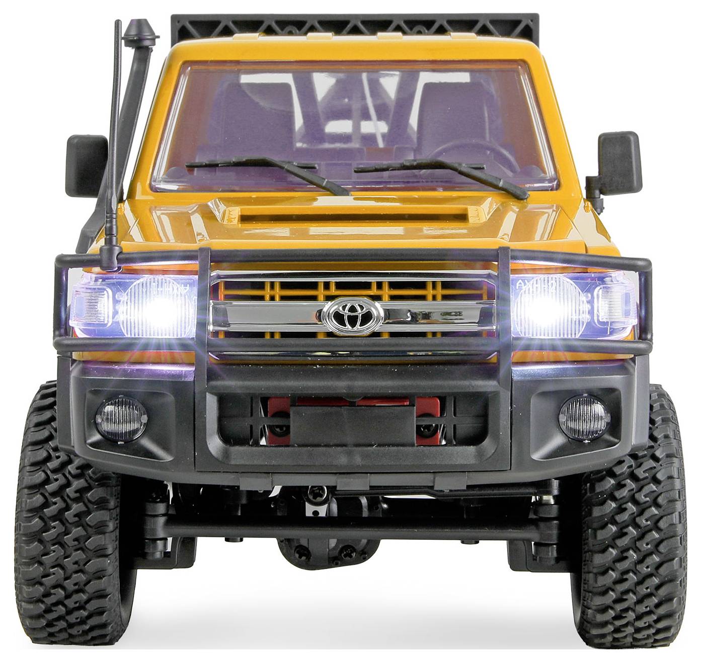 Vue de face d'un camion tout-terrain Toyota orange avec les phares allumés, présenté sur un fond blanc.